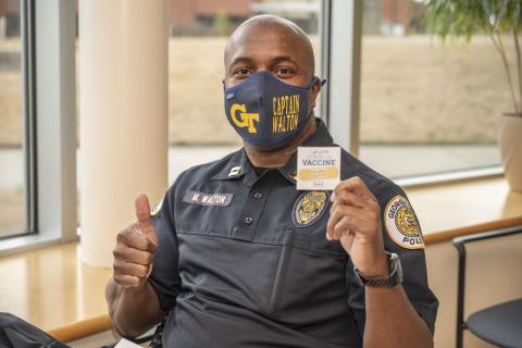 Captain Marcus Walton shows his vaccination card. 